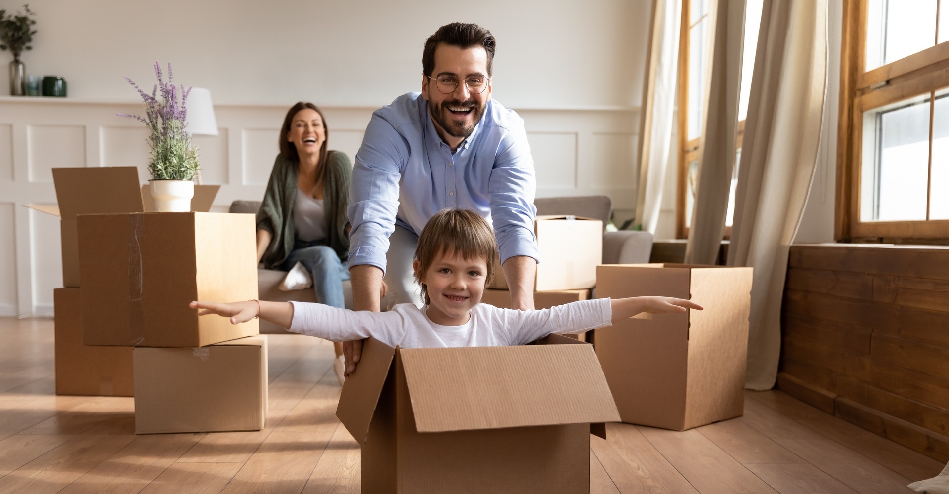 Two parents with their kid playing in a box